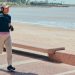 A woman jogs along the beachfront pathway in Montevideo, Uruguay, enjoying a sunny day.